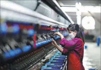  ?? YANG CHENGLI / XINHUA ?? An employee works on a loom at a silk production factory in Rongjiang county, Guizhou province.