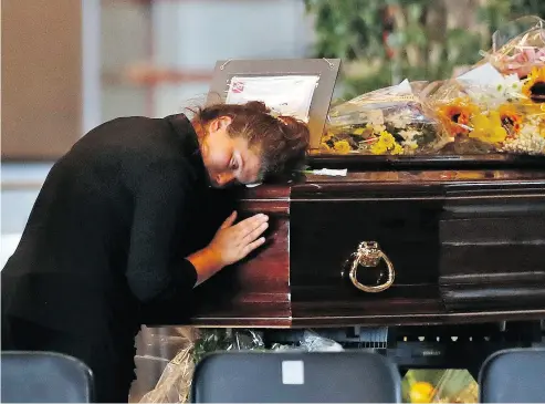  ?? ANTONIO CALANNI / THE ASSOCIATED PRESS ?? A woman mourns a victim of the collapsed Morandi Bridge at the Fiera di Genova exhibition centre in Genoa, where some of the coffins were laid in state on Friday. The accident has put a spotlight on Italy’s troubled infrastruc­ture.