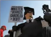  ?? JACQUELYN MARTIN — THE ASSOCIATED PRESS FILE ?? In this file photo, Gan Golan, of Los Angeles, dressed as the “Master of Degrees,” holds a ball and chain representi­ng his college loan debt, during Occupy DC activities in Washington.