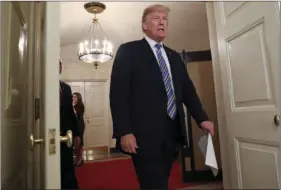  ??  ?? In this March 23 photo, President Donald Trump walks into the Diplomatic Room of the White House in Washington, to speak about the $1.3 trillion spending bill. Days of conflictin­g and misleading statements from Trump and his top aides have fueled new...