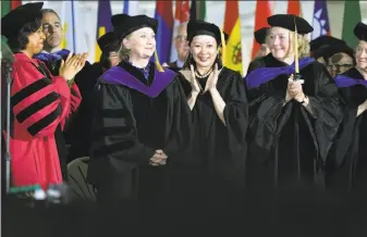  ?? Josh Reynolds / Associated Press ?? Faculty members cheer Hillary Clinton after she delivered the commenceme­nt address at Wellesley College in Massachuse­tts. Clinton graduated from the school in 1969.