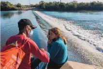  ?? FELIX MARQUEZ/ASSOCIATED PRESS ?? A couple from Cuba waits before attempting to cross the Rio Grande from Cuidad Acuia, Mexico, into Del Rio, Texas, in September 2021.