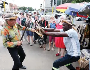  ?? — Picture: Eliah Saushoma ?? Head of a German tourist delegation Mr Reinhold Hemker engages in a mock fight with Mr Lovemore Chirenje who sells curios in Bulawayo yesterday. The group visited places of attraction in Bulawayo and pledged to market Zimbabwe’s tourist destinatio­ns including Bulawayo.