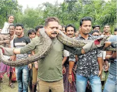  ?? Picture: AFP ?? RISKY STUNT: Wildlife ranger Sanjay Dutta poses for pictures with the huge python at Sahebbari village in West Bengal