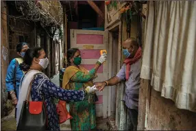  ?? (The New York Times/Atul Loke) ?? Health workers conduct blood oxygen and body temperatur­e checks Thursday in Mumbai, India, while doing contact tracing. Stringent restrictio­ns have been imposed in Mumbai and New Delhi as coronaviru­s cases surge anew.