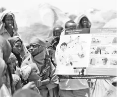  ??  ?? Aid workers use a visual aid to give lessons on sanitation to people living in a makeshift camp for the internally displaced on the outskirts of Baidoa town. — AFP photo