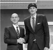  ?? MIKE STOBE/GETTY IMAGES ?? Commission­er Adam Silver welcomes Anzejs Pasecniks, drafted by the Magic 25th and then traded to the 76ers.