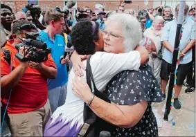  ?? STEVE HELBER/AP PHOTO ?? Susan Bro, mother of Heather Heyer, who was killed during last year’s Unite the Right rally, embraces supporters Sunday after laying flowers at the spot where her daughter was killed in Charlottes­ville, Va.
