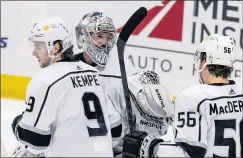  ??  ?? Kings goaltender Troy Grosenick, center, is congratula­ted by Kempe and Kurtis MacDermid after he made 33 saves in L.A.’s 5-1 victory over the Ducks.