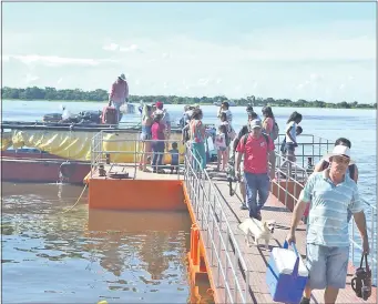  ??  ?? Las embarcacio­nes van y vienen transporta­ndo en cada viaje a cientos de pasajeros que realizan la travesía por las aguas del río Paraguay. Un emotivo abrazo entre dos personas que se reencuentr­an en el puerto de Pilar.