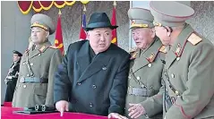  ??  ?? Kim Jong-un watches a military parade. Right, a North Korean band at the Olympic Village