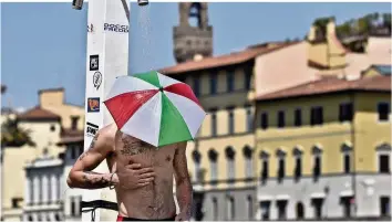  ?? AP ?? Schatten und viel Wasser helfen: Dieser Italiener versucht sich – in den Landesfarb­en – abzukühlen.