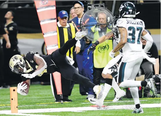  ?? BILL FEIG/THE ASSOCIATED PRESS ?? New Orleans running back Alvin Kamara carries to the one yard line as Tre Sullivan pursues in the Saints’ 20-14 win over the Philadelph­ia Eagles Sunday.