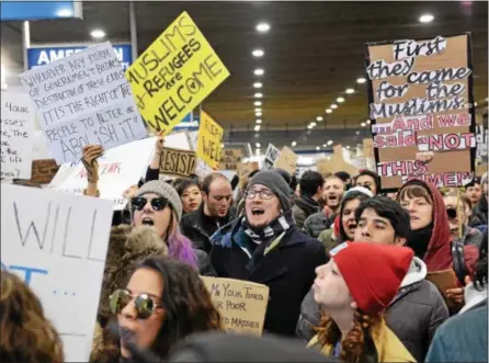  ?? RICK KAUFFMAN – DIGITAL FIRST MEDIA ?? Protesters gather outside the American Airlines arrival terminal at the Philadelph­ia Internatio­nal Airport to protest an executive order denying immigrants from seven Muslim-majority countries entry into the United States, recently signed by President...