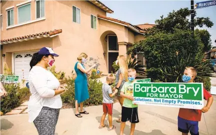  ??  ?? San Diego City Councilwom­an Barbara Bry (in blue) hosts a campaign event handing out yard signs last month in Carmel Valley.