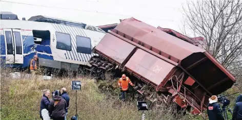 ?? FOTO: DPA ?? Bahnmitarb­eiter sichteten gestern an der Bahnstreck­e zwischen Neuss und Meerbusch die Schäden an den Waggons der verunglück­ten Züge.