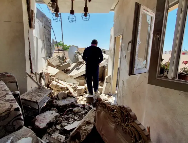  ?? © Afp/mahmud Turkia ?? Un habitant de Tripoli traverse les ruines de son appartemen­t, détruit par les forces de l’armée nationale libyenne, le 1er mai 2020.