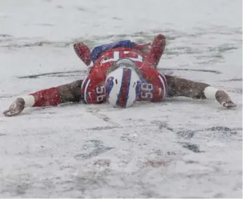  ?? SETH WENIG/THE ASSOCIATED PRESS ?? Buffalo’s Ryan Davis makes a snow angel on the field before the Bills-Colts game last Sunday. Buffalo won in overtime to go to 7-6, but still might need some heavenly help to make the playoffs.