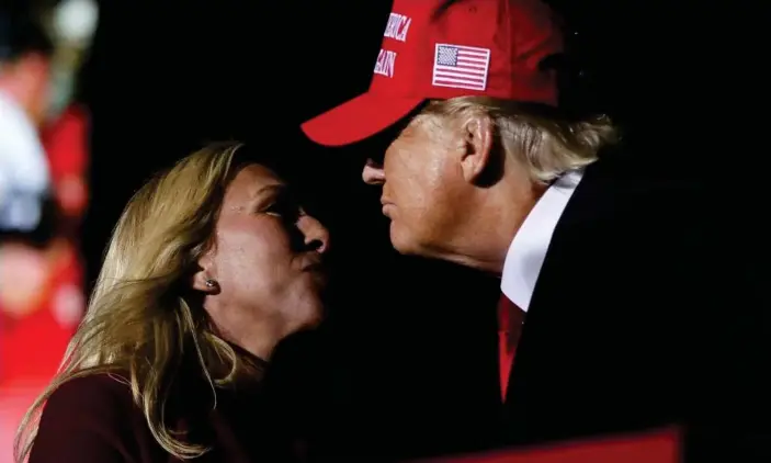  ?? Photograph: Alyssa Pointer/Reuters ?? Representa­tive Marjorie Taylor Greene salutes former president Donald Trump during a rally in Commerce, Georgia, on 26 March 2022.