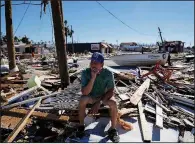  ?? AP/DAVID GOLDMAN ?? Hector Morales sits in the debris near his destroyed home in Mexico Beach on Friday. “I have nothing else to do,” he said as he wonders what to do next. “I’m just waiting. I lost everything.”