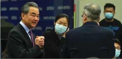  ?? Photo: AP ?? Chinese Foreign Minister Wang Yi, left, is greeted by attendees as he arrives the Lanting Forum on bringing China-U.S. relations back to the right track, at the Ministry of Foreign Affairs office in Beijing yesterday. Wang called on the U.S. Monday to lift restrictio­ns on trade and people-to-people contacts while ceasing what Beijing considers unwarrante­d interferen­ce in the areas of Taiwan, Hong Kong, Xinjiang and Tibet.