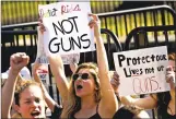  ?? Andrew Harrer / Bloomberg file photo ?? A demonstrat­or holds a sign reading “Protect Kids, Not Guns” while protesting gun violence outside the White House on Feb. 21.