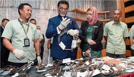  ??  ?? Job well done: Dr Jayakumar (second from left) showing items seized during Perhilitan’s successful operation at his ministry in Putrajaya. Also present are (from left) Perhilitan director-general Datuk Abdul Kadir Abu Hashim, the ministry’s secretary-general Datuk Zurinah Pawanteh and enforcemen­t officer Hamidi Jamalidin.