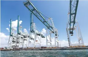  ?? AP FILE PHOTO/WILFREDO LEE ?? Large cranes unload container ships at PortMiami in Miami.