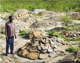  ??  ?? South Sudanese refugee James Malish, whose mother and sister recently died days apart, visits their graves and stands by that of his sister Lucia Tokosa, on an isolated patch of land designated by Ugandan officials on the edge of Bidi Bidi, the world's...