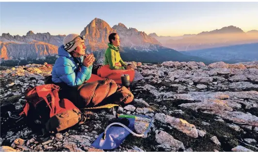  ?? FOTO RALF GANTZORN ?? Die Berge sind auch Orte der Stille und der Einsamkeit. Das Foto zeigt zwei Frauen bei der Meditation in den Dolomiten.