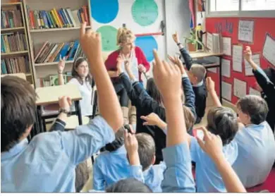  ??  ?? Alumnos atienden a su profesora en un colegio inglés.