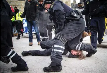  ?? ASHLEY FRaSER ?? A Parliament­ary Protective Services officer kneels on the head of one of multiple anti-fascism and anti-racism activists who were detained at a rally on Parliament Hill on Saturday morning.