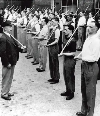  ??  ?? Members of the Civicorps – men who were waiting to be called up – train with broomstick­s in place of rifles in June 1940. Lowe challenges the notion that Britain stood alone in the fight against Germany at this point in the war