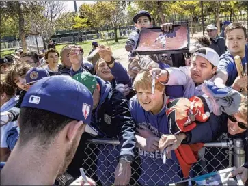  ?? Gina Ferazzi Los Angeles Times ?? FANS SEEK an autograph from Cody Bellinger in Glendale, Ariz., in 2019. One study estimated that out-ofstate visitors spent $168 million on Cactus League trips last year, before the pandemic stopped spring training.