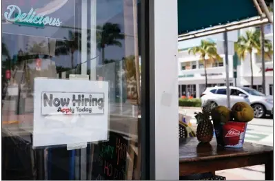  ?? (AP/Wilfredo Lee) ?? A “Now Hiring” sign sticks to the window of a restaurant Thursday in Miami Beach, Fla. The number of Americans seeking unemployme­nt aid fell last week by 3,000 to 787,000.