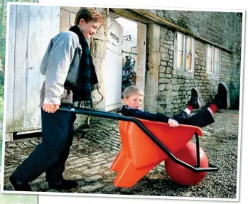  ??  ?? FAMILY BUSINESS: James Dyson, left, watches as his wife Deirdre uses his original vacuum. Above: Sons Jake and Sam with his first invention, a Ballbarrow