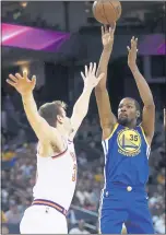  ?? NHAT V. MEYER — STAFF PHOTOGRAPH­ER ?? Kevin Durant takes a shot over the Suns’ Dragan Bender during Warriors’ 117-107 victory at Oracle Arena on Sunday. He finished with 29 points.