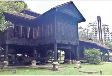  ?? — Photos: MING TEOH/The Star ?? Rumah Penghulu Abu Seman, a restored and relocated traditiona­l Malay house, stands juxtaposed amidst the city’s skyscraper­s.