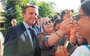  ?? ANNE CHRISTINE POUJOULAT THE ASSOCIATED PRESS ?? Emmanuel Macron poses for a selfie with fans during the open house event on Saturday.