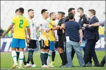  ??  ?? Brazil and Argentina’s players talk as the soccer game is interrupte­d by health authoritie­s during a qualifying soccer match for the FIFA World Cup Qatar 2022 at Neo Quimica Arena stadium in Sao Paulo, Brazil. (AP)