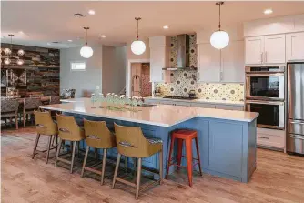  ??  ?? The kitchen backsplash is a small space, but it’s a showstoppe­r with patterned ceramic tile. The large island is meant to accommodat­e the Diazes and guests.