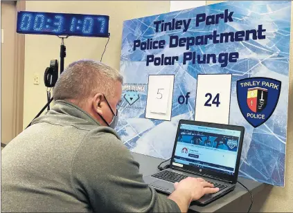  ?? MIKE NOLAN/DAILY SOUTHTOWN PHOTOS ?? Tinley Park police Sgt. Darren Persha checks on donations raised during the department’s Polar Plunge to benefit Special Olympics Illinois.