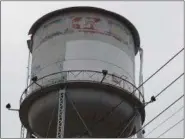  ?? BILL DEBUS — THE NEWS-HERALD ?? A new coat of white paint covers a portion of the Madison water tower, which is viewed on Dec. 3 looking south on Route 528 toward Interstate 90, near McDonald’s. The paint is being applied to the structure in the first phase of a project to turn the tower site into a welcome area for tourists. With winter approachin­g, the paint project recently was put on hold and will be completed in the spring.