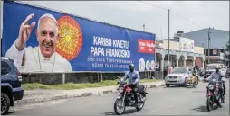  ?? ?? The Canadian Press
People drive past a banner welcoming Pope Francis to Goma, Democratic Republic of Congo, Friday.