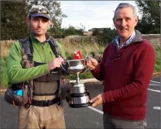  ??  ?? John Mc Caughey receives the Glyde Cup from Roddy Minogue, chairperso­n of Dundalk Salmon Anglers Associatio­n.