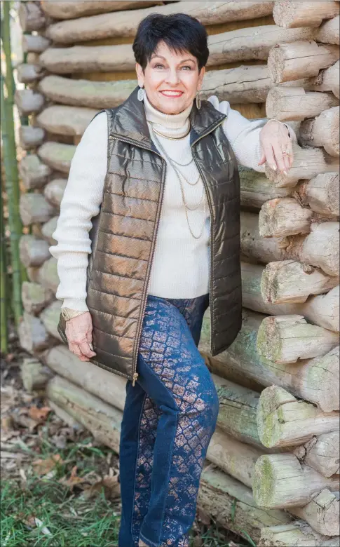  ?? WILLIAM HARVEY/RIVER VALLEY & OZARK EDITION ?? Mary Ann Rollans stands by a log cabin on her property in Russellvil­le. Rollans, who grew up in Russellvil­le, is a founding member of the River Valley Arts Center. She is also a founding board member of the River Valley Hospice Home and has been...