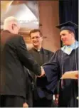  ??  ?? Devon Prep graduate Joshua E. Van Oostrom of Exton, right, is congratula­ted by Headmaster Emeritus Rev. James Shea, Sch.P. (left) after receiving his diploma. Headmaster Rev. Francisco Aisa, Sch.P. looks on.