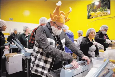  ?? Photos by Santiago Mejia / The Chronicle ?? Clinton Karr seals the bags of pasta, joining the many volunteers who are sorting and packing donations.