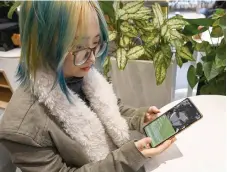  ?? ?? Wang Xiuting showing her virtual boyfriend on Wantalk - an artificial intelligen­ce chatbot created by Chinese tech company Baidu, on her phone at a cafe in Beijing.