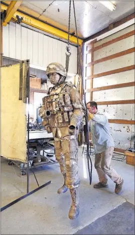  ?? [FRED SQUILLANTE/DISPATCH PHOTOS] ?? Josh Becker positionin­g one of the 750-pound statues during the creation process at Coopermill Bronzework­s